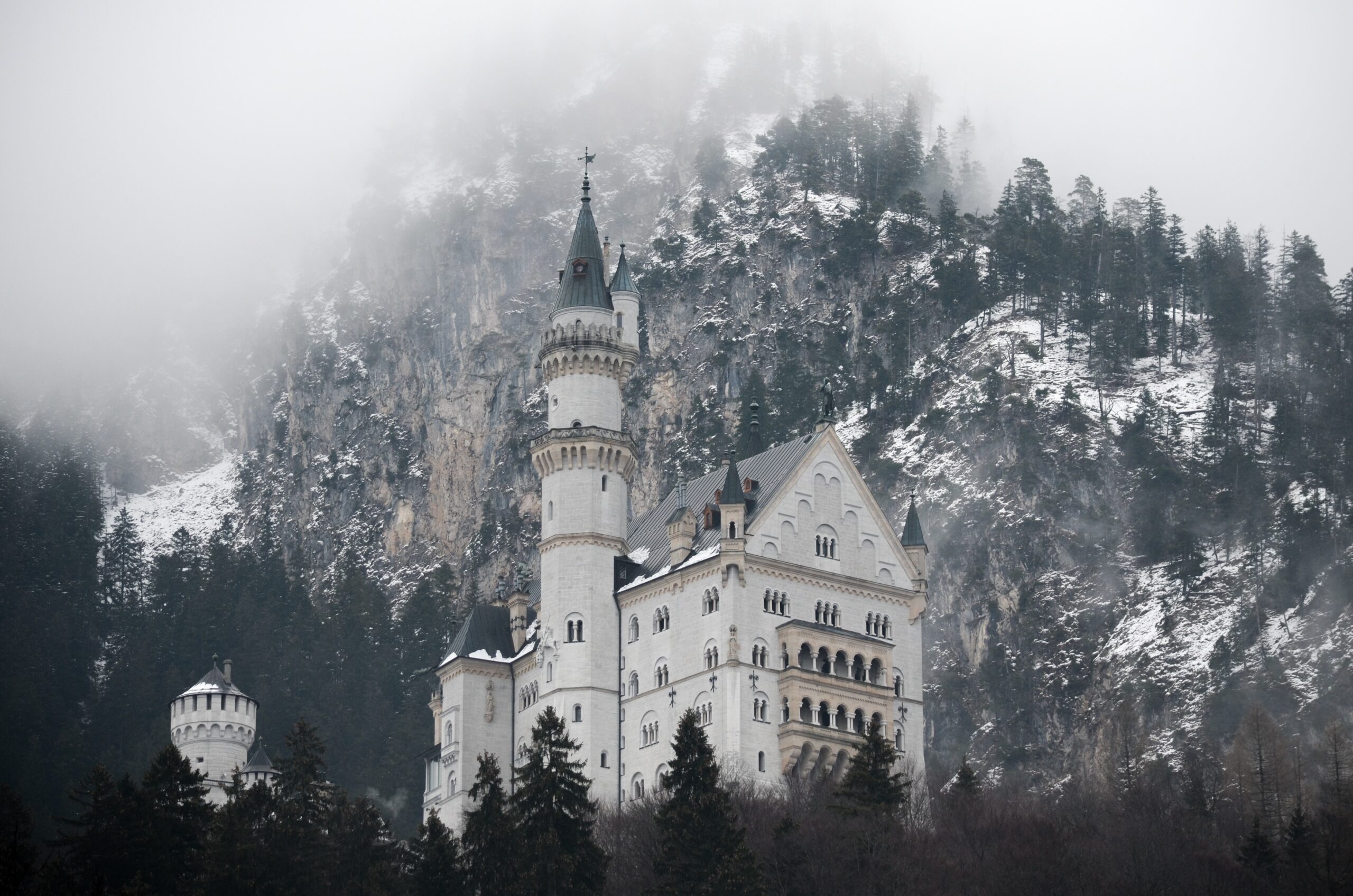 Neuschwanstein Castle near Munich in Germany can be seen in the autumn. It stands on top of a mountain surrounded by forest