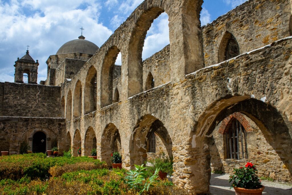 The arches and dome of the old church in the San Jose Missions can be seen