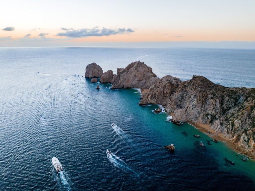 Land's End and Lover's Beach at Los Cabos. The rocky peninsula juts out into the sea at sunset