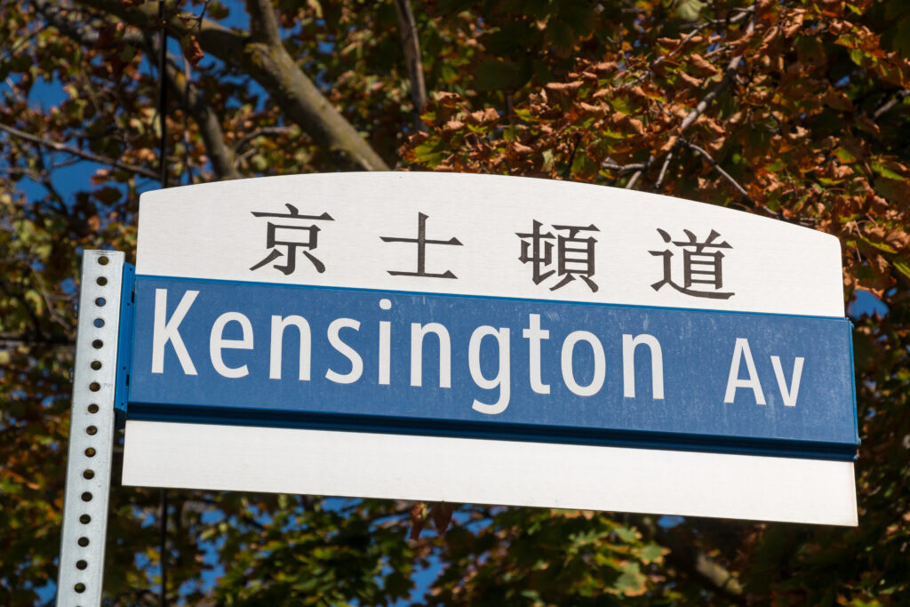A Street sign in Toronto saying Kensington Avenue, with the same in Chinese