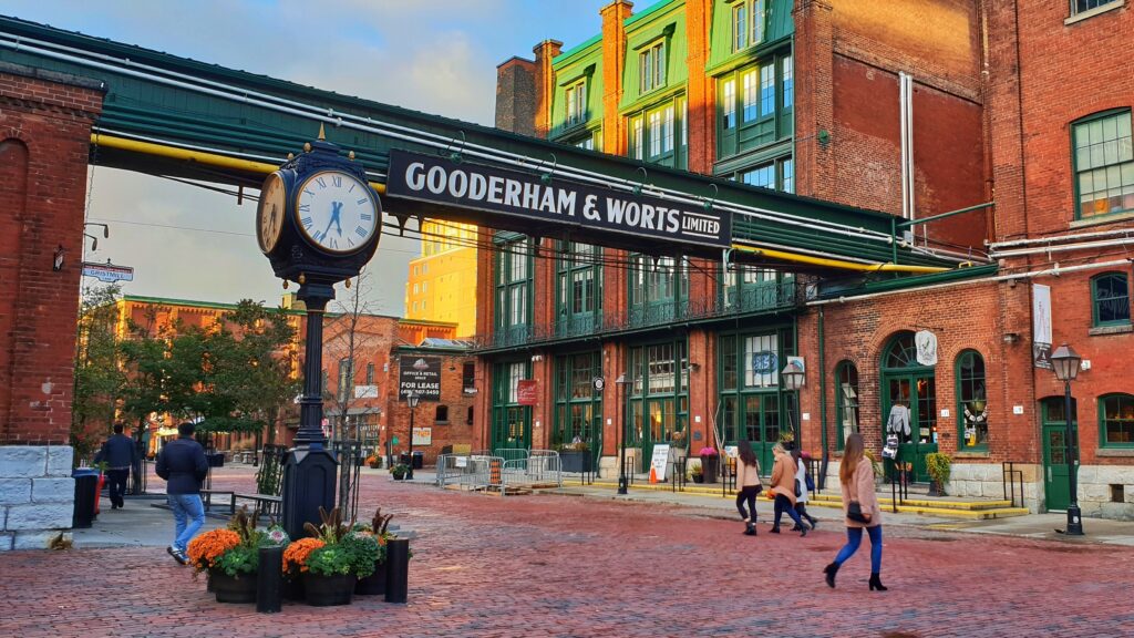 People walk past the old Gooderham and Worts Distillery, which has now been converted into the Distillery District