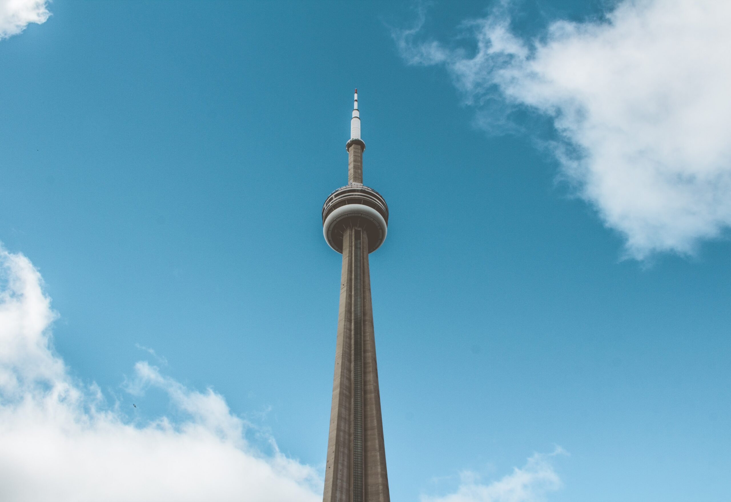 The CN Tower stands alone against a blue sky