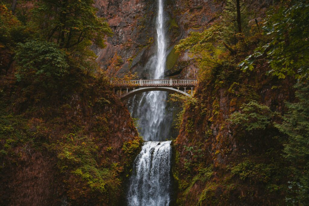 Water tumbles over Multnomah Falls near Portland, Oregon, surrounded by the reds and oranges of the fall foliage