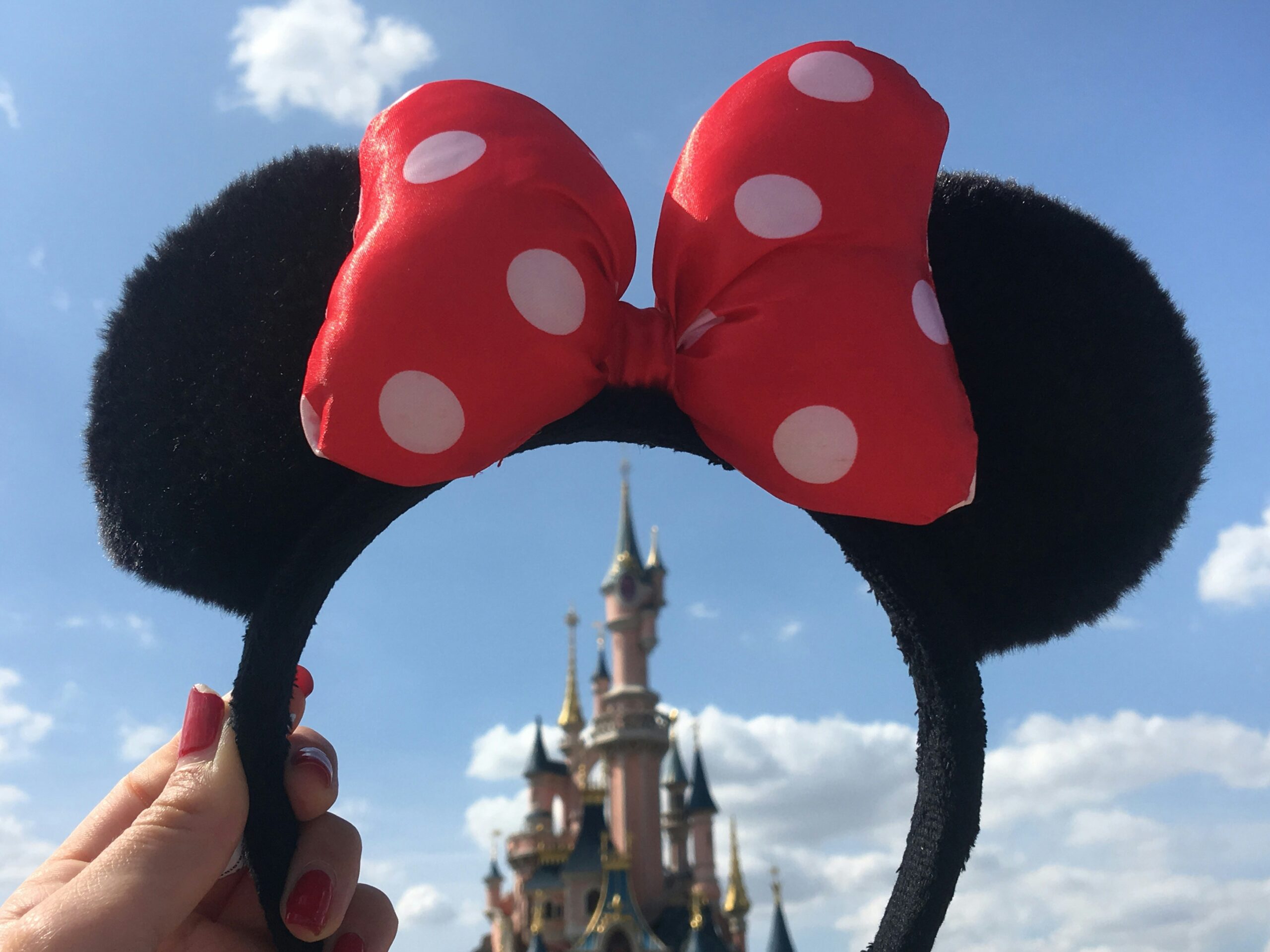 Sleeping Beauty Castle is seen through a Minnie Mouse hairband at Disneyland Paris