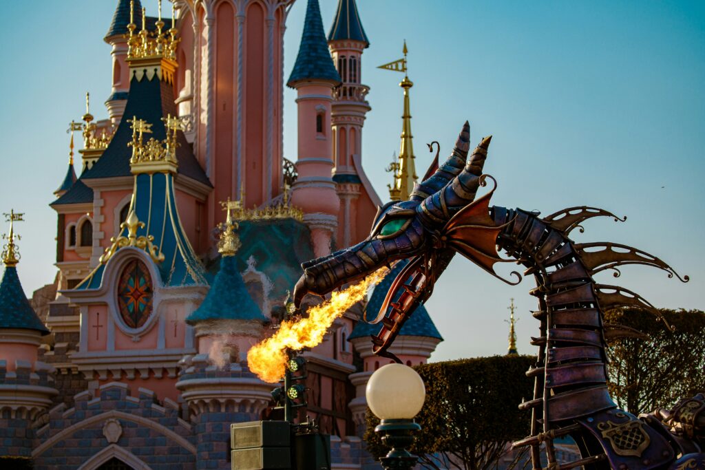A dragon breaths fire outside of Sleeping Beauty Castle